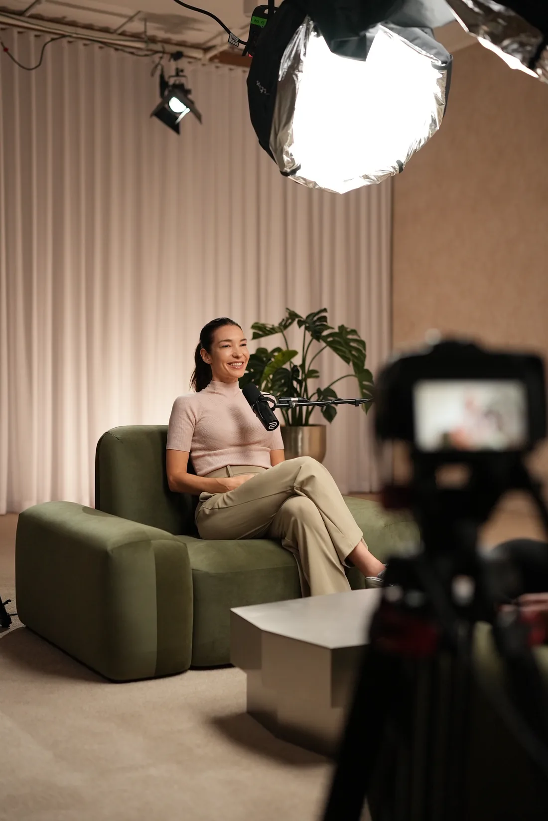 A BuilderHQ user seated for a filmed interview, lit from one side against a dark backdrop.