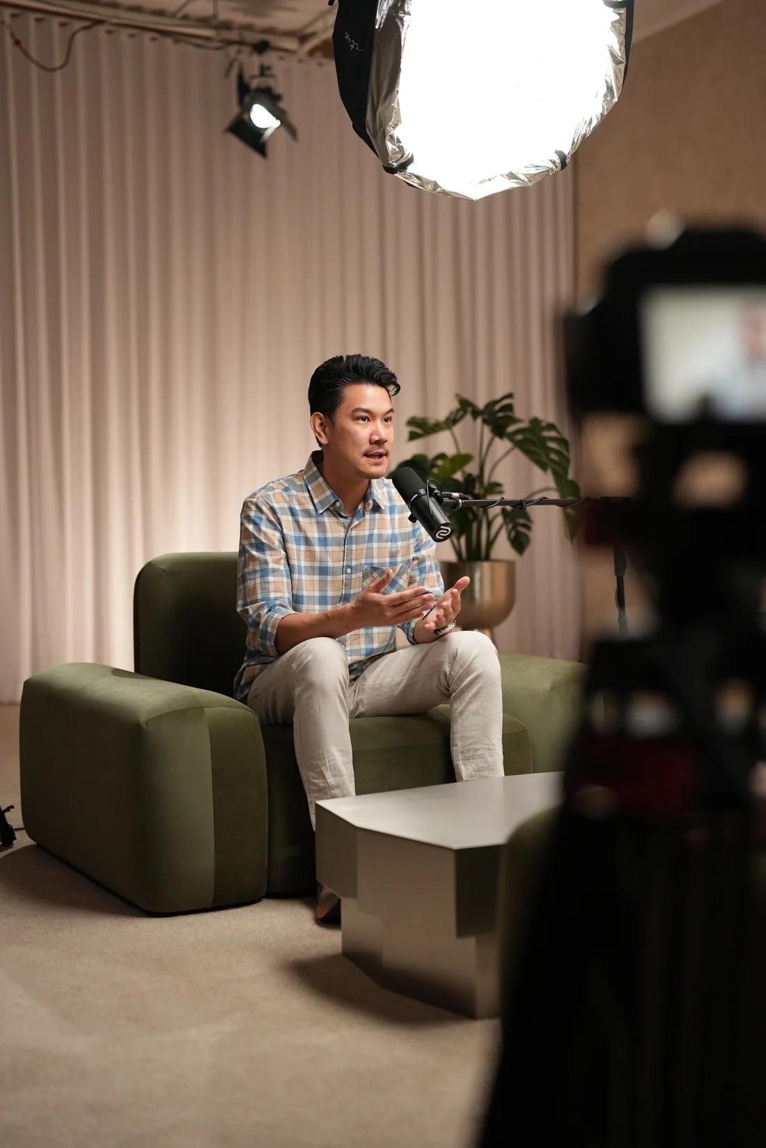 A second BuilderHQ user seated for a filmed interview, microphone in frame.